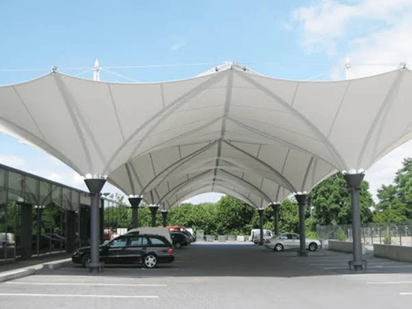 Kanopi membran putih elegan untuk area parkir mobil yang luas.